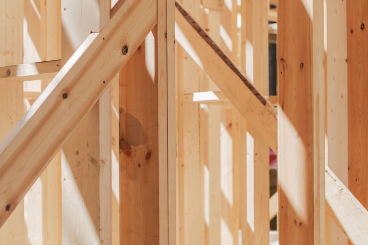Holzständerwerk eines Rohbaus mit Stielen und Diagonalstreben im Sonnenlicht